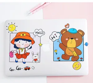 Close-up detail of cute cartoon waterproof PVC stickers applied to a white laptop lid