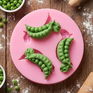 Dettaglio dello stampo in silicone a baccello di pisello con fondente verde su legno