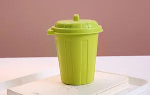 Close-up of a mini green desktop trash can with lid used as a pen holder