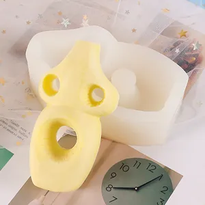 Vue détaillée du moule à bougie abstrait en silicone avec le produit fini jaune