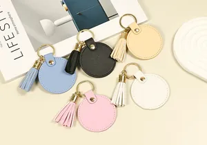 Lot de porte-clés ronds en cuir colorés avec pompons sur fond de style de vie