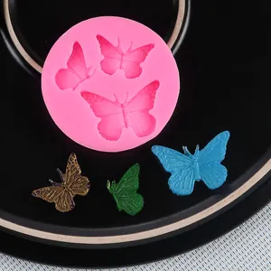 Detail view of pink silicone butterfly mold with three colored butterfly crafts