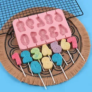 Detail of pink silicone number lollipop mold with finished colorful floral chocolates