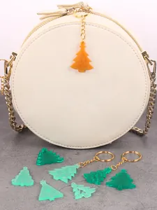 Close-up of DIY green and orange resin Christmas tree charms and keychains for jewelry