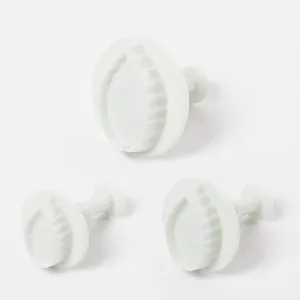 Detail view of set of three white plastic rose leaf plunger cutters for cake decoration