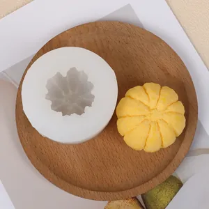 Dettaglio di uno stampo in silicone a forma di zucca 3D con candela gialla su vassoio