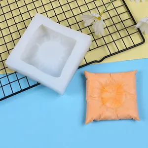 Detailed view of a square pillow-shaped silicone mold with realistic fabric textures.