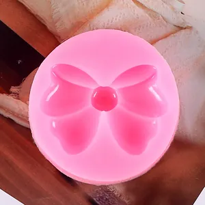 Vista dettagliata di uno stampo in silicone rosa a forma di fiocco per dolci