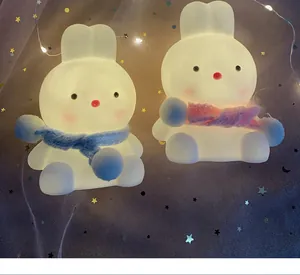 Detail view showing cute illuminated rabbit night lights with blue and pink scarves.