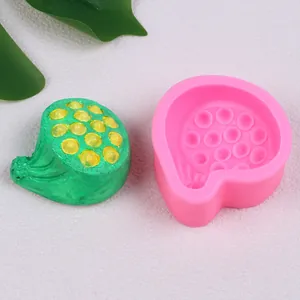 Detailed view of a pink lotus pod silicone mold with a finished green plaster model