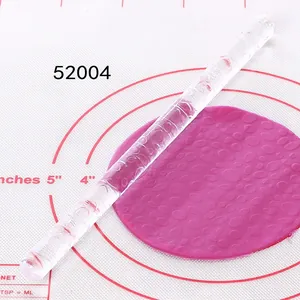 Detalle de rodillo de acrílico con patrón para repujado de fondant en tapete de horneado