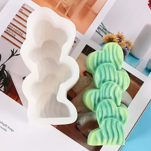Detailed view of a white silicone mold and a green stacked heart-shaped soap bar