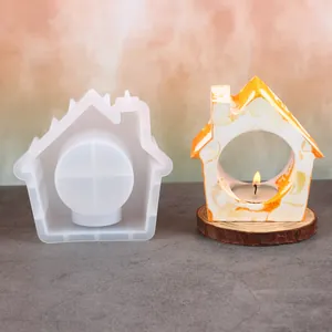 Detail view of a house-shaped silicone mold and a finished marble-patterned candle holder.