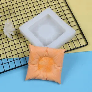 Detailed view of square pillow shaped silicone mold with finished orange resin cushion