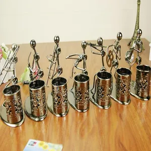 Detailed display of vintage metal nut musician figurines and desk pen holders collection