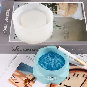 Close-up of a white silicone mold and finished light blue geometric ashtray design