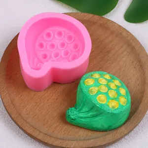 Detailed view of lotus seed pod silicone mold and finished green candle on a wooden tray