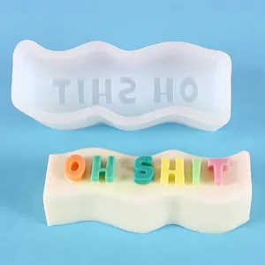 Detailed view of wave-shaped silicone mold and colorful 'OH SHIT' slogan candle