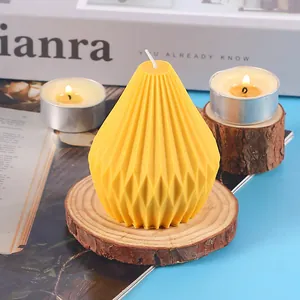 Close-up of yellow geometric aromatherapy candle with pleated texture on wooden base