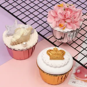Close-up of metallic pink, silver, and gold cupcake liners on a decorative grid