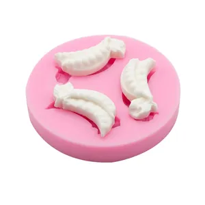 Vista dettagliata dello stampo in silicone rosa con tre pezzi di fondant a forma di verdura