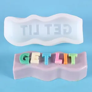 Close-up of DIY wavy silicone mold and colorful 'GET LIT' slogan candle sample for crafting