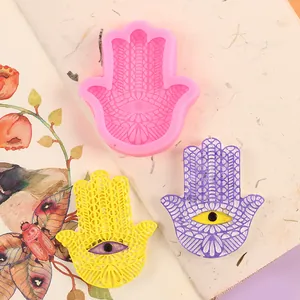 Vista dettagliata dello stampo in silicone Hamsa rosa e dei sottobicchieri in resina finiti
