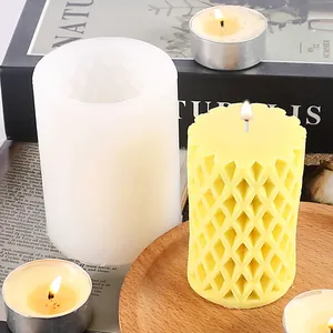 Detail view of a geometric hollow-out candle silicone mold with a yellow finished candle