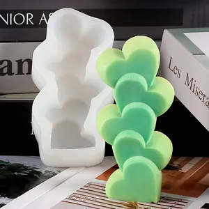 Detailed macro shot of 5-cavity stacked heart silicone mold and finished green soap