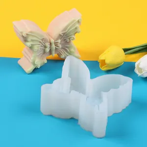 Primer plano de molde de silicona de mariposa para jabón y velas en fondo colorido.