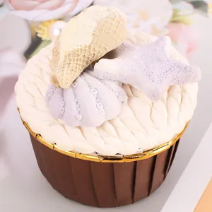 Detail of brown rolled-edge muffin cup with decorative shell and starfish topping