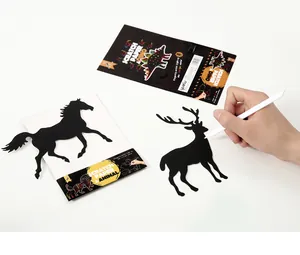 Detailed view of DIY scratch art kit with animal-shaped die-cut paper and stylus tool.