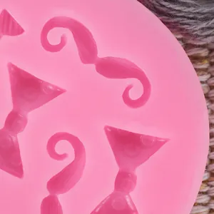 Detail of pink silicone mold with moustache and bowtie shapes for cake decorating