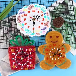 Close-up of finished diy epoxy resin clocks in gingerbread and festive gift box shapes