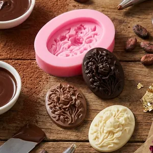 Detailed view of the oval rose floral silicone mold with finished chocolates on a wood table.