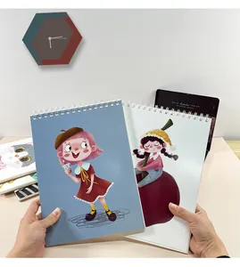 Detail showing two A4 spiral sketchbooks with cute cartoon girl illustrations for kids.