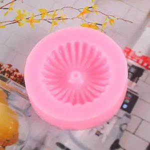 Vista dettagliata dello stampo in silicone rosa tondo con trama scanalata a raggiera