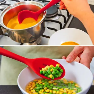 Close-up of red heat-resistant silicone kitchen ladle and slotted spoon in use