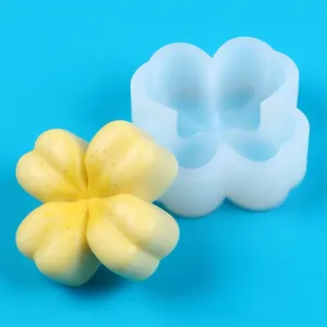 Detail view of a flower-shaped silicone mold and the finished yellow clover candle.
