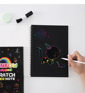 Detailed macro view of a child drawing a colorful cat on a black rainbow scratch note