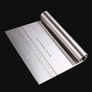 Close-up of stainless steel dough scraper with precise metric and inch scale markings.