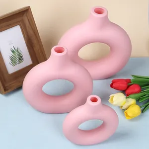 Modern set of three pink donut-shaped decorative vases with a smooth matte finish