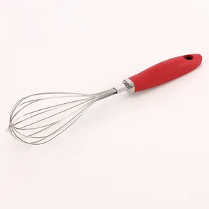 Primo piano di una frusta manuale in acciaio inox con manico in silicone rosso