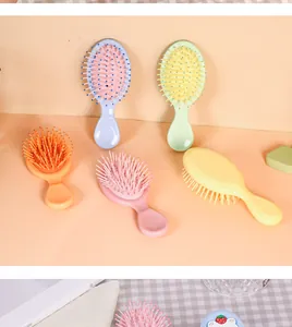 Detailansicht von fünf farbenfrohen Mini-Pastell-Massagehaarbürsten auf Pfirsichhintergrund