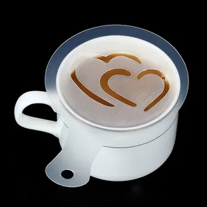 Close-up of a plastic coffee latte art stencil with a double heart pattern on a mug.