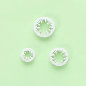 Macro-weergave van drie witte plastic uitstekers voor fondant en koekjes op een groene basis