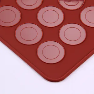Detailopname van de cirkelvormige patronen op een rode siliconen bakmat voor macaron koekjes