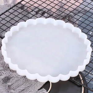 Detailed macro view showing the scalloped edge of a round white silicone mold for DIY resin