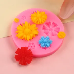 Detail view of a pink sunflower silicone mold featuring colorful finished floral resin pieces