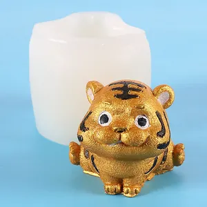 Primo piano di una statuetta di tigre dorata e il suo stampo in silicone